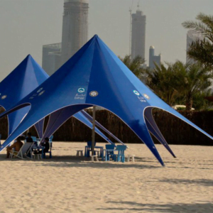 A star marquee tent set up on a beautiful beach, ready for a lively beach party.